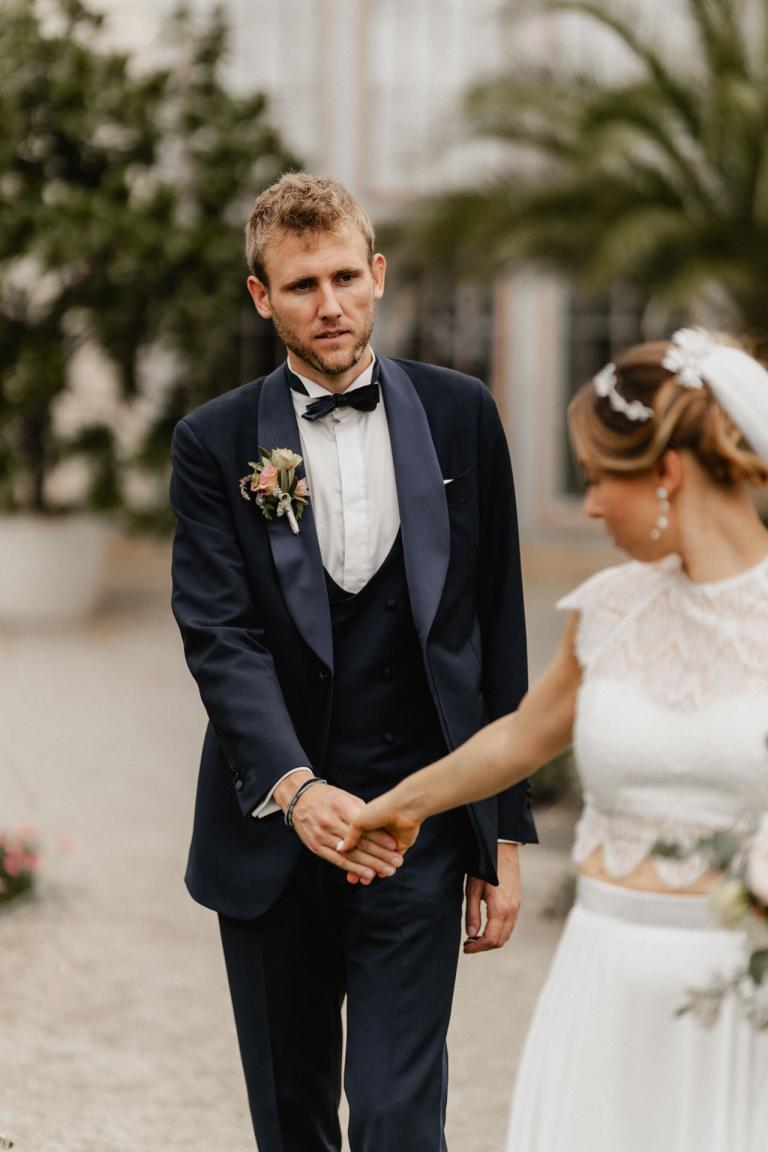 Braut zieht Bräutigam hinter sich her während Hochzeit Alte Orangerie Schloss Rosenau