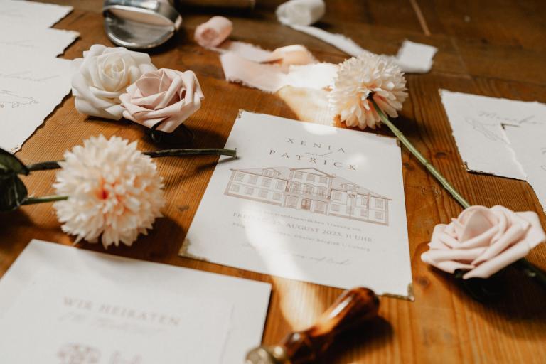 Einladung zur Hochzeit Alte Orangerie Schloss Rosenau umrandet von Blumen und Accessoires