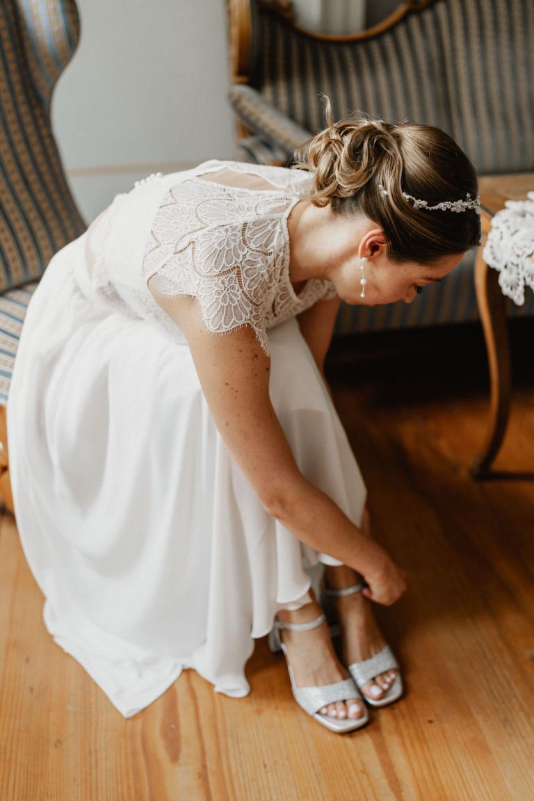 Braut zieht Schuhe an für Hochzeit Alte Orangerie Schloss Rosenau