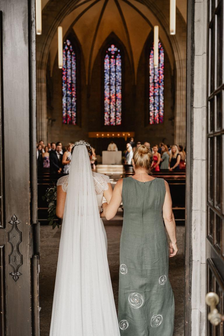 Braut zieht mit Mutter in Kirche ein