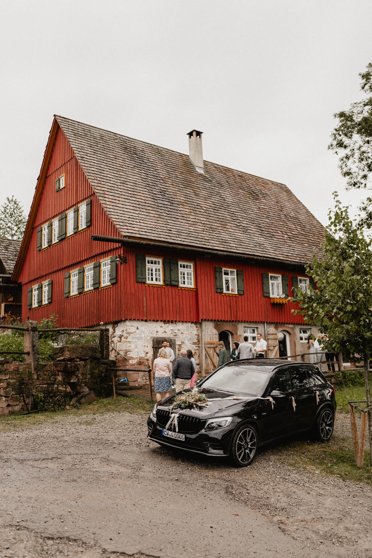 Aufnahme von Hochzeitslocation mit Hochzeitsauto im Vordergrund