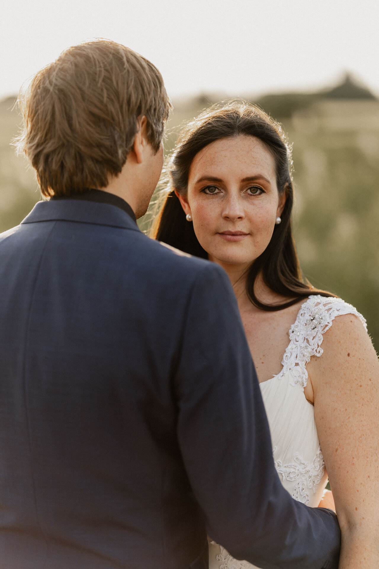 Braut blickt über Schulter von Bräutigam, Bild von Hochzeitsfotograf Karlsruhe