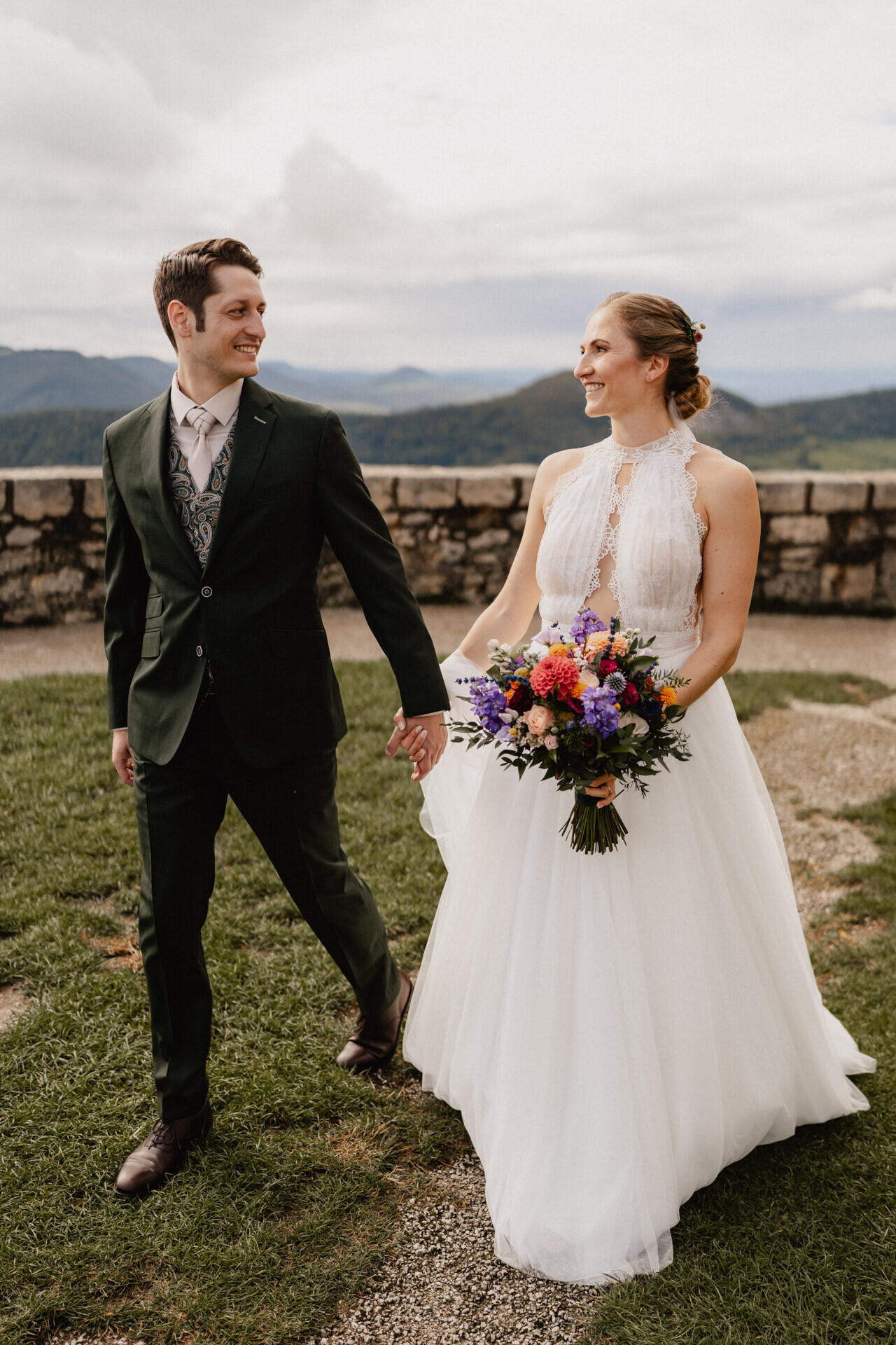 Brautpaar läuft Hand in Hand bei ihrer Hochzeit auf Burg Hohenneuffen