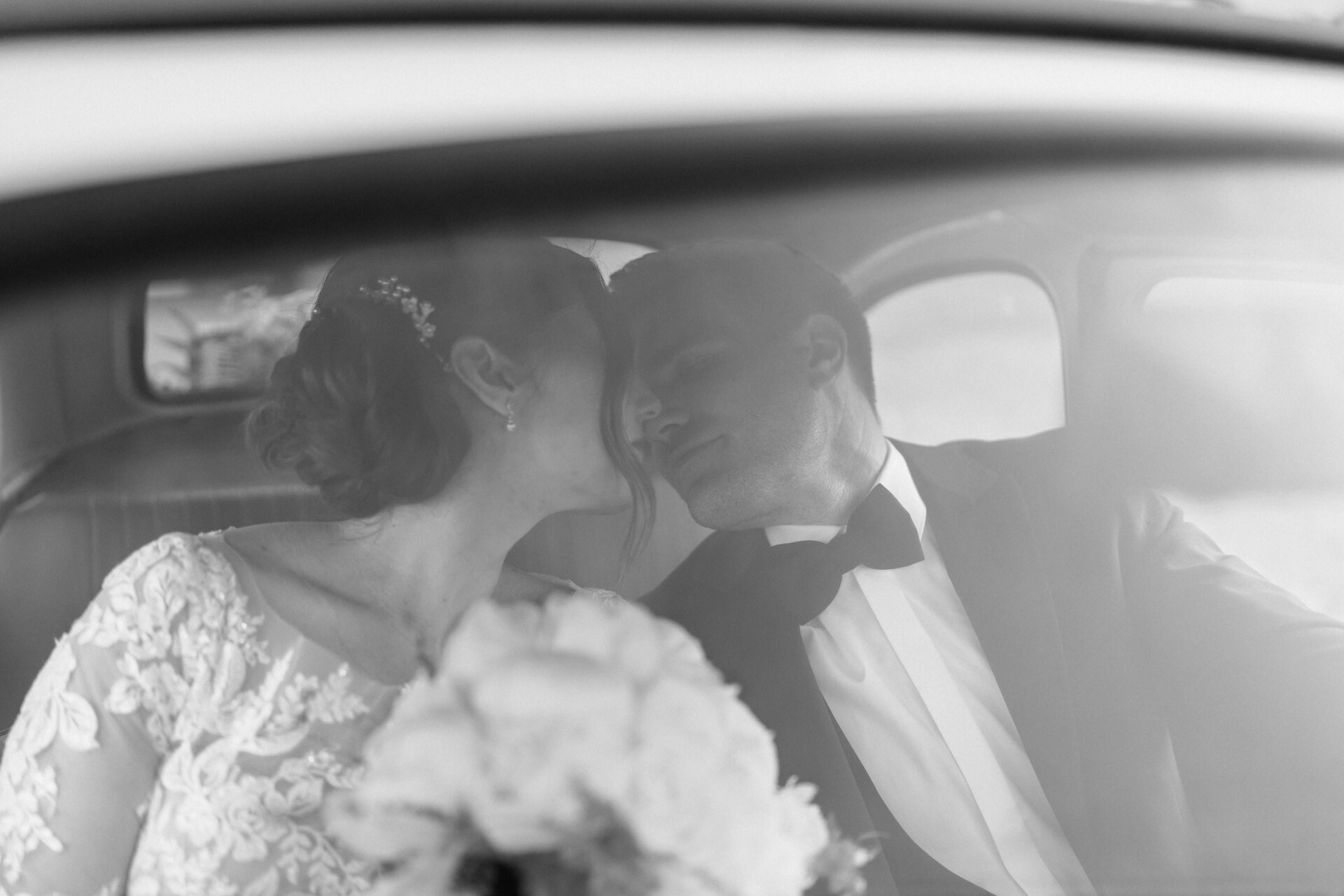Brautpaar küsst sich in Hochzeitsauto