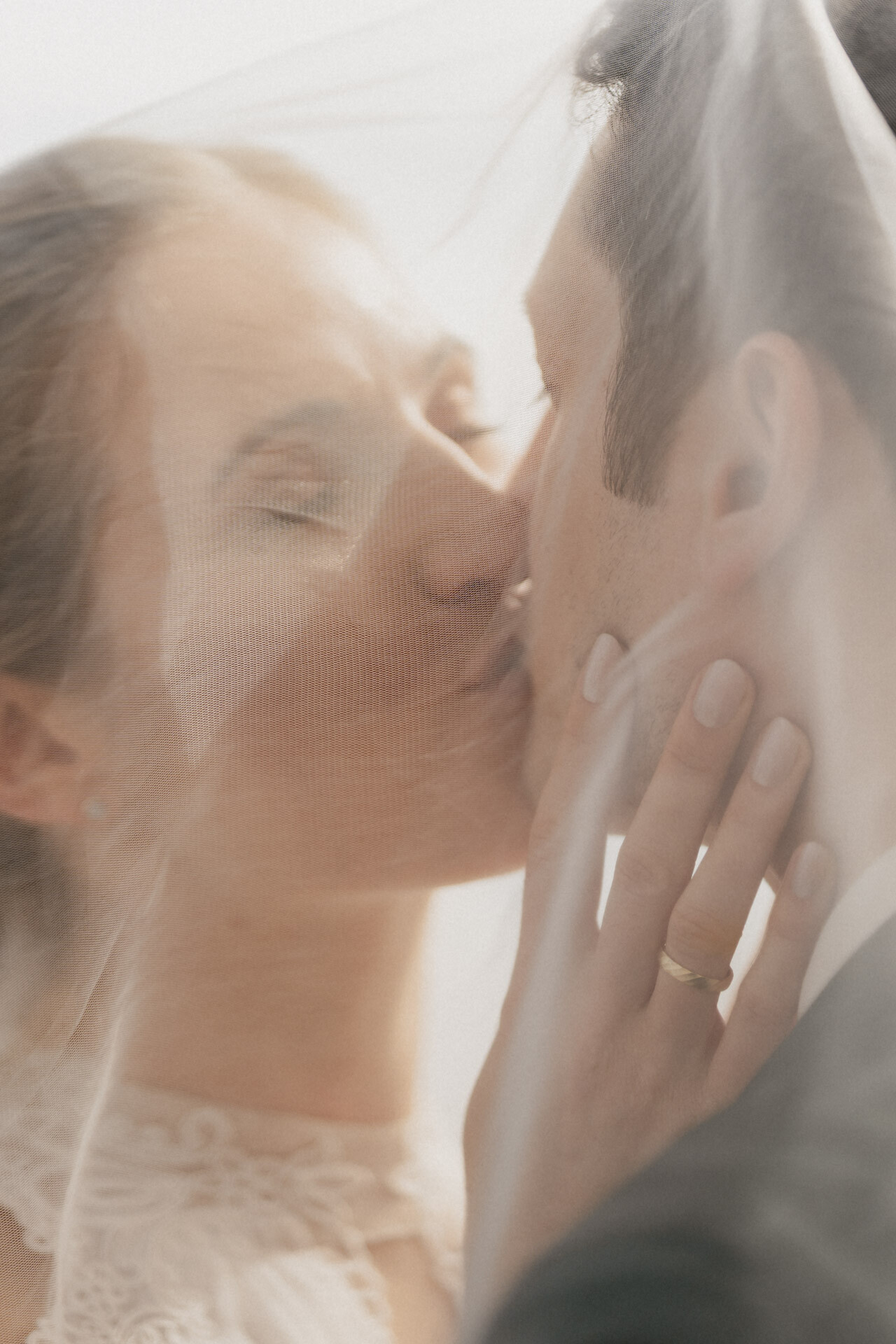 Brautpaar küsst sich unter Schleier für Hochzeitsfotograf Stuttgart